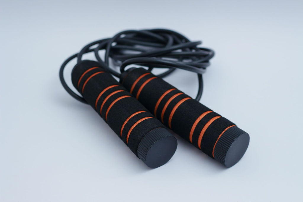 Adjustable speed jump rope with foam handles on a white background