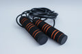Adjustable speed jump rope with foam handles on a white background