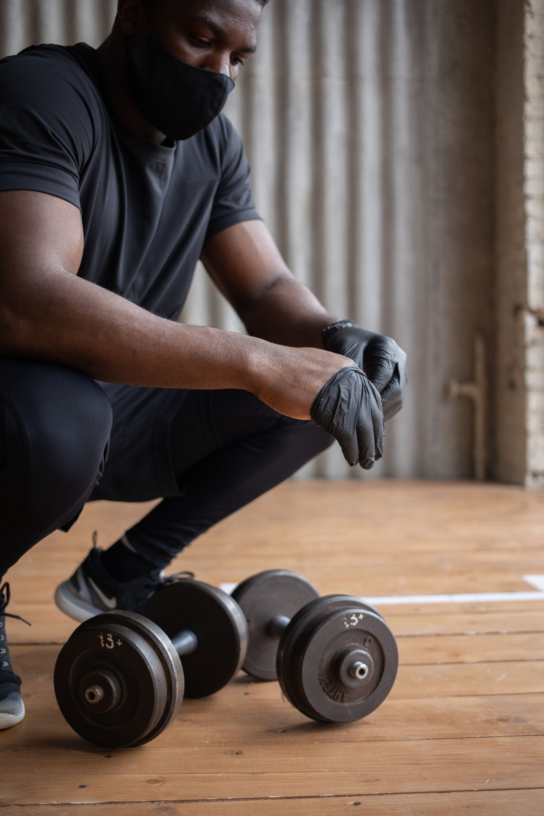 Athlete wearing training gloves while lifting a dumbbell